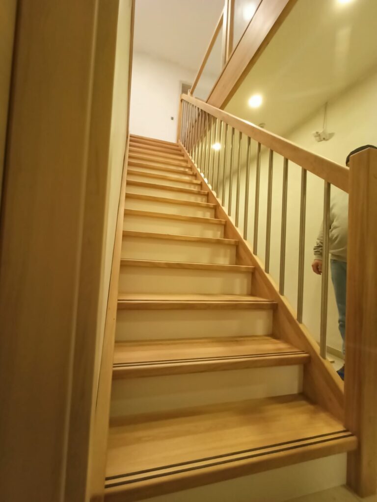 Geschlossene Wangentreppe mit lackierten Holzstufen