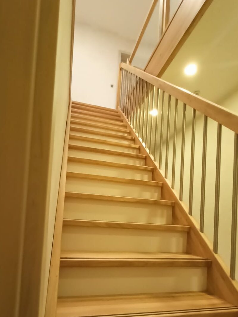 Geschlossene Wangentreppe mit lackierten Holzstufen