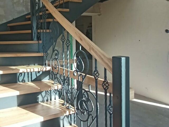 Holztreppe mit Schmiedegeländer